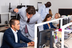 Mean boss standing over sitting employee and yelling
