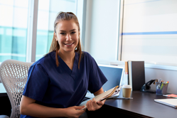 Young Certified Nursing Assistant at Desk