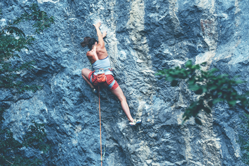 Woman climbing up Rock Wall