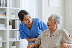 Young woman taking care of elderly hospice woman