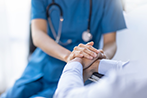 Nurse Holding Senior's Hand in Hospital