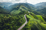 Long winding road on top of green mountain range