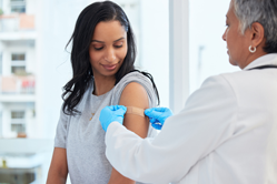Young woman getting immunized by physician